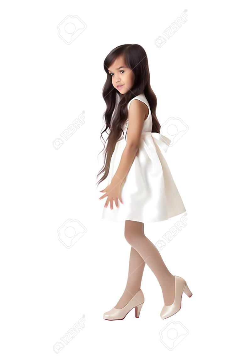 优雅苗条的小女孩的东部外观与长黑发尝试对妈妈的高跟鞋鞋的女孩脚非常大-孤立的白色背景