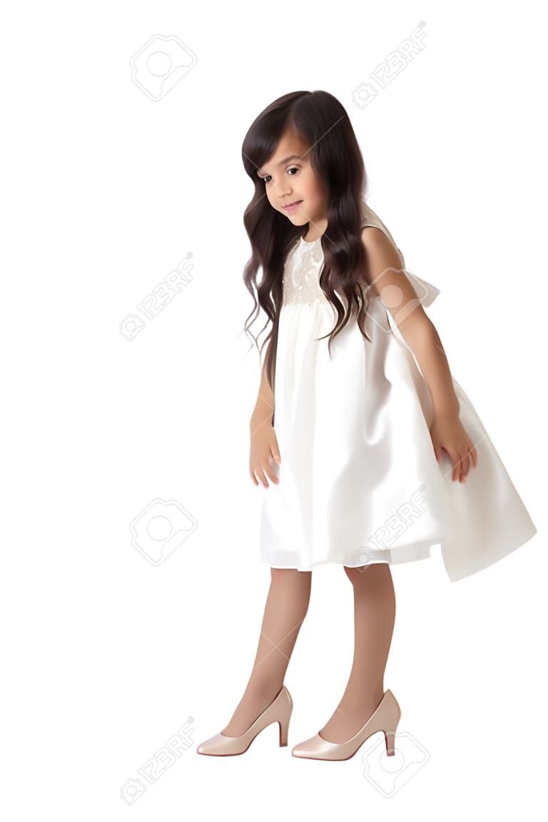 Elegáns, karcsú kislány Kelet megjelenés, hosszú fekete hajú, próbál anya magas sarkú cipő. Cipő a lábon, a lányok nagyon nagy - elszigetelt fehér háttér