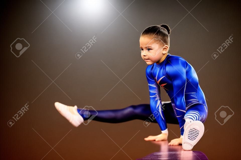 Una gimnasta de la muchacha realiza una posición en sus manos.