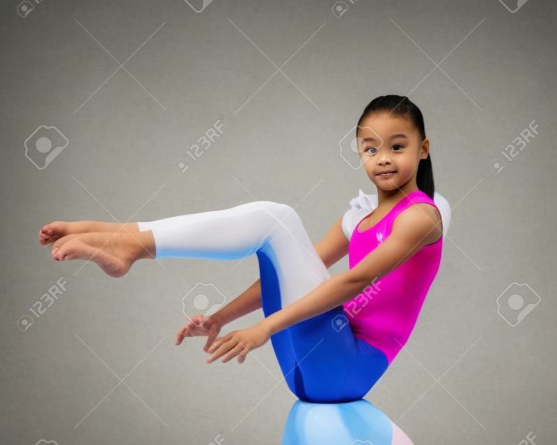 Cimnastikçi yerde akrobatik bir unsur sergiliyor.