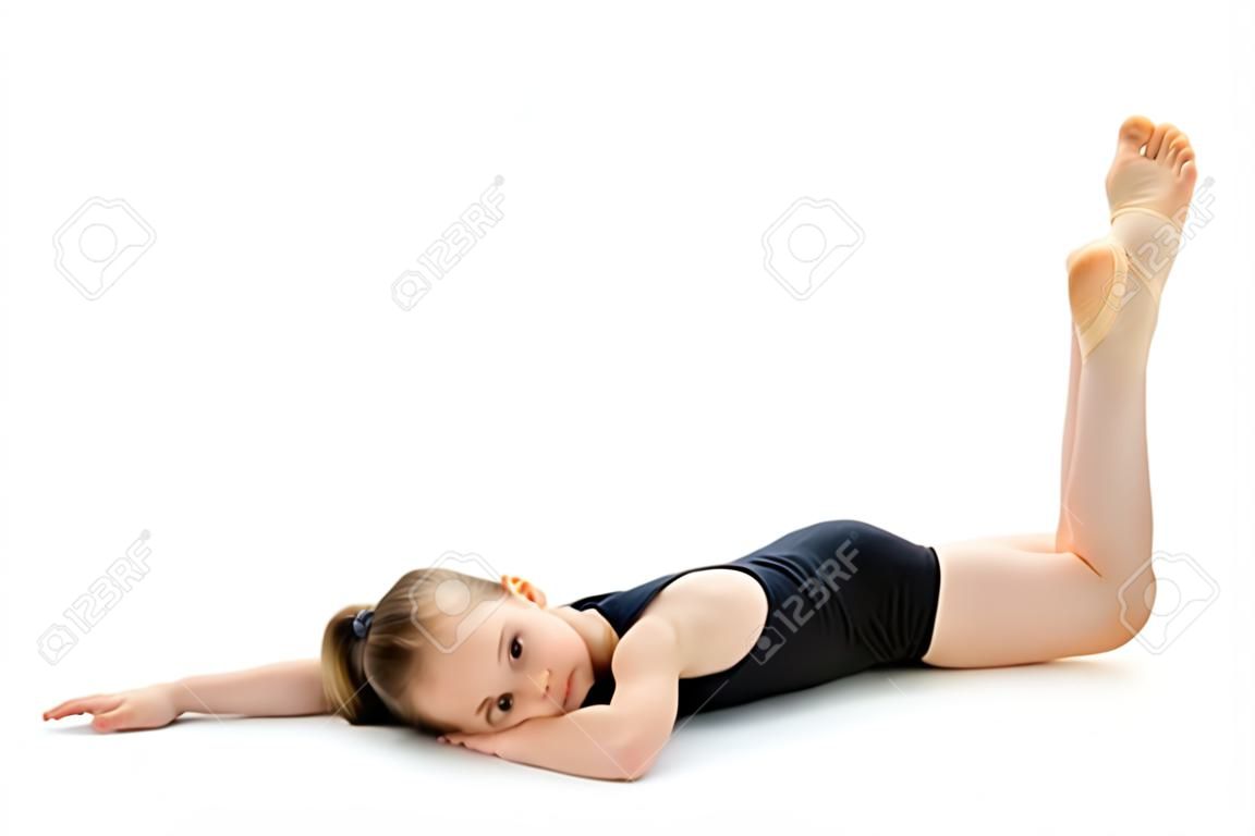 La petite gymnaste exécute un élément acrobatique sur le sol.