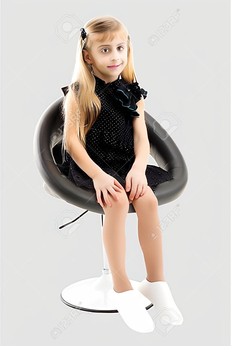 Little girl is sitting on a chair