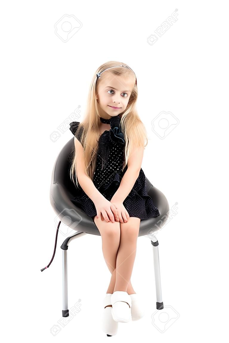 La bambina è seduta su una sedia