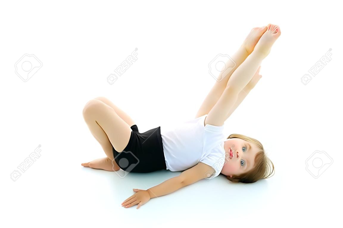 Charming little girl doing gymnastic exercises in the studio on