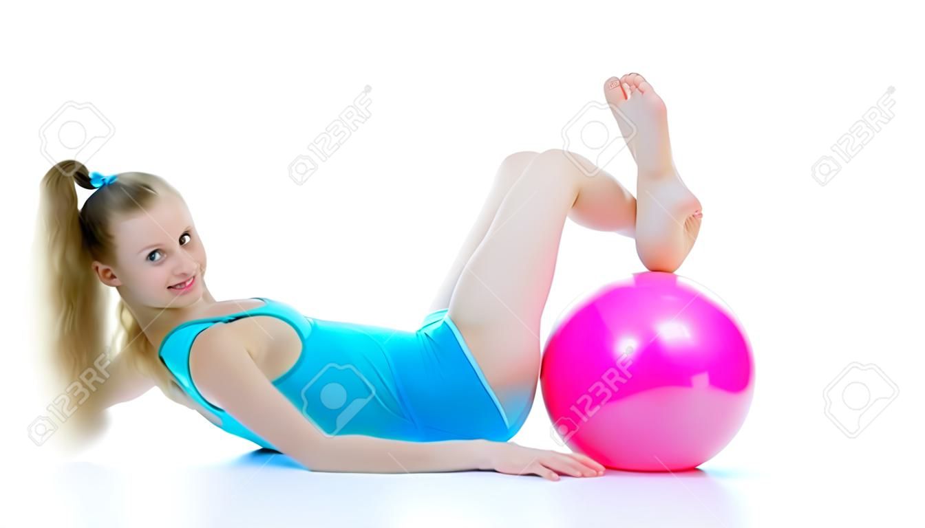 Gimnasta chica realiza ejercicios con la pelota.