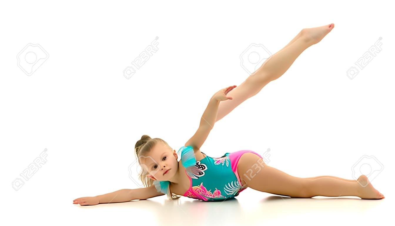 Menina encantadora fazendo exercícios de ginástica no estúdio em um fundo branco