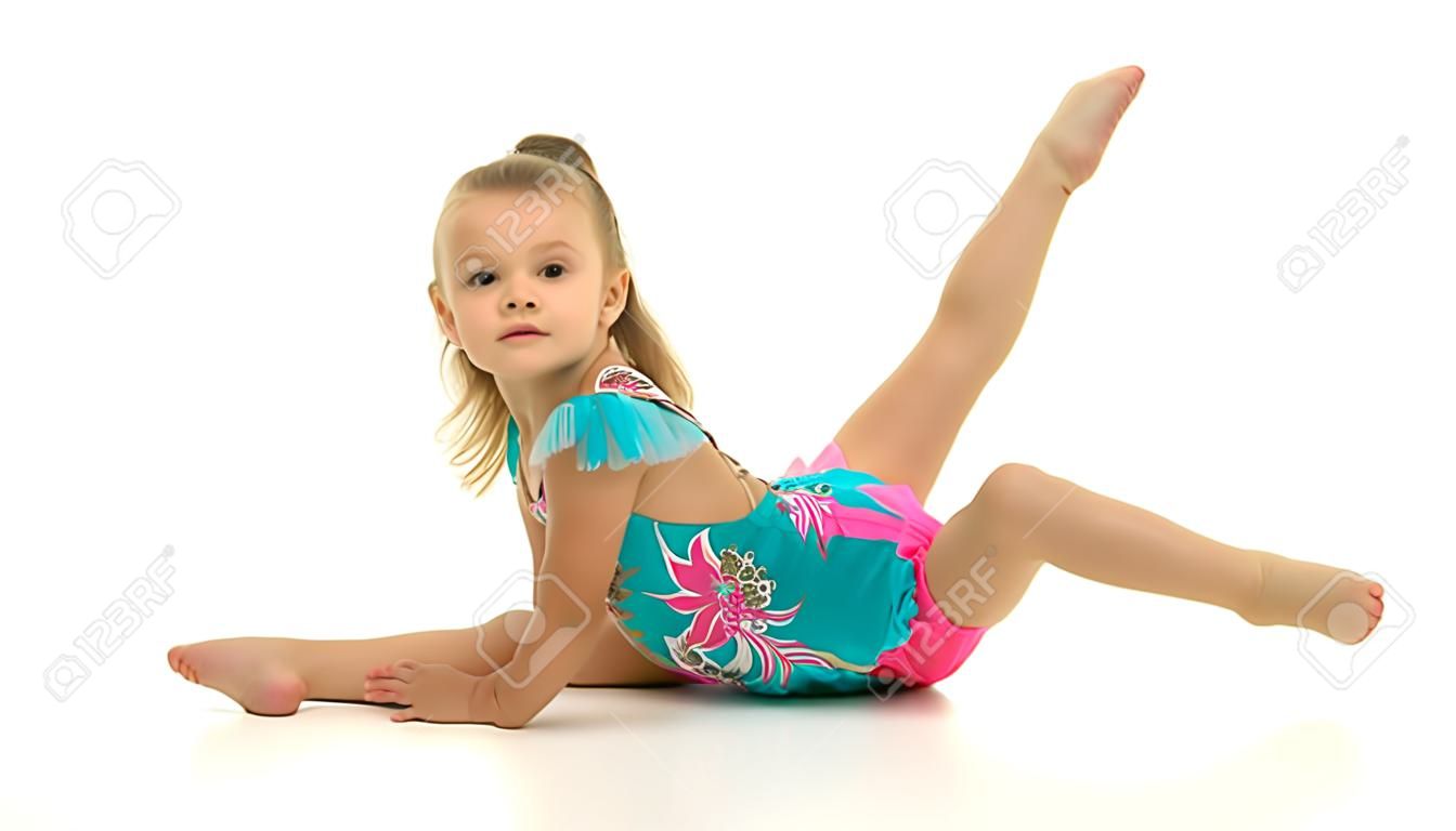 Menina encantadora fazendo exercícios de ginástica no estúdio em um fundo branco
