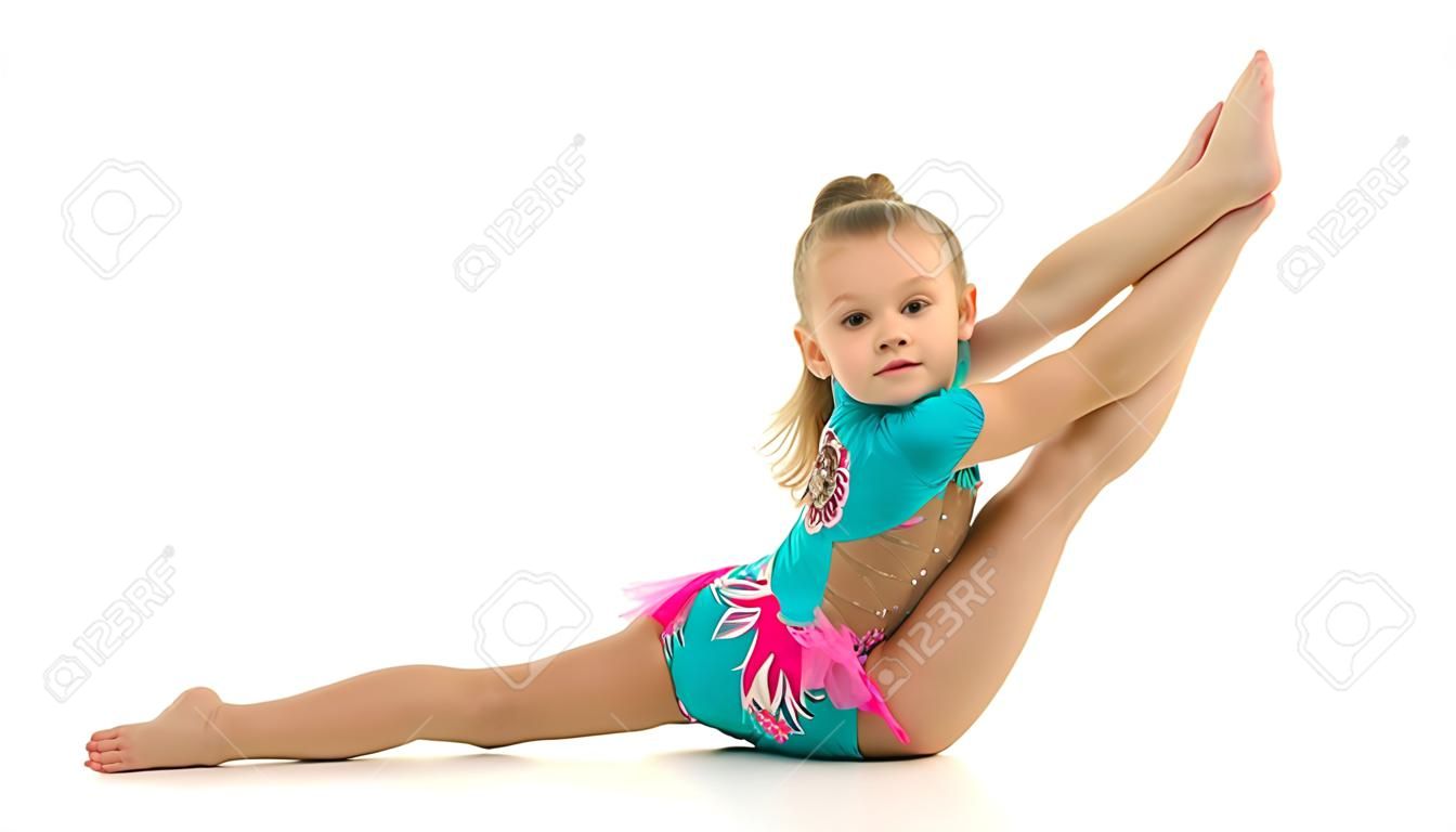 Encantadora niña haciendo ejercicios de gimnasia en el estudio sobre un fondo blanco.