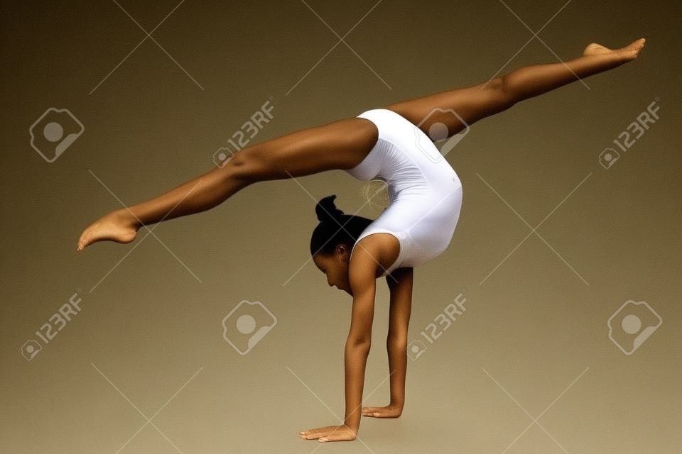 Beautiful girl gymnast performs a handstand.