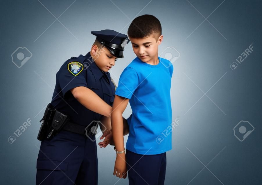Un policier arrête et menottes un jeune malfaiteur pour adolescents mâle.
