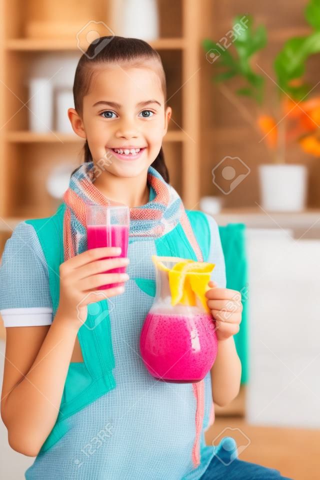
Smiling girl holding pitcher of homemade juice