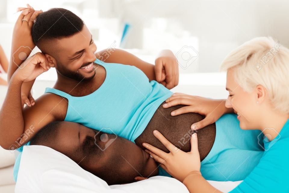 Futur père tenant par la main sur le ventre de sa femme et de sentir le bébé bouger
