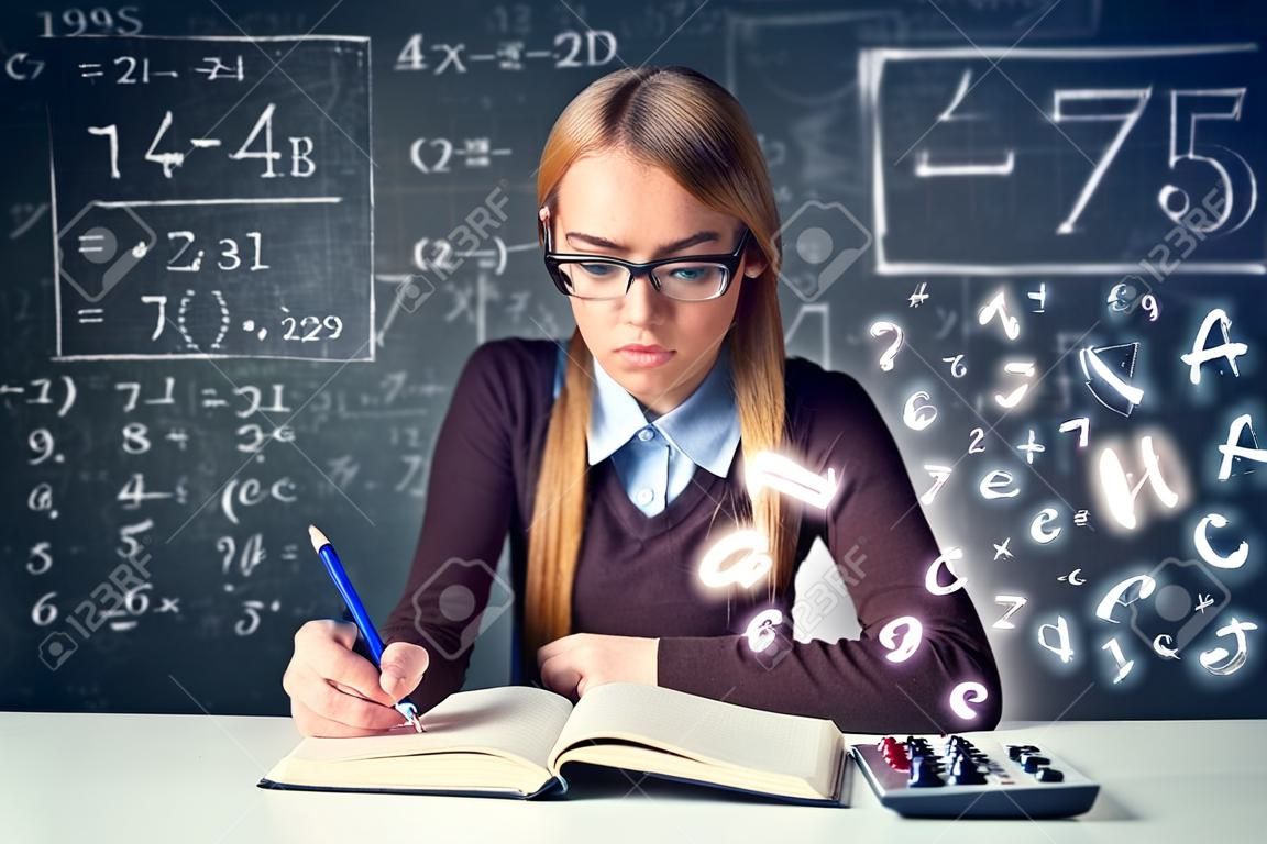 Schoolgirl doing  mathematics with math formulas