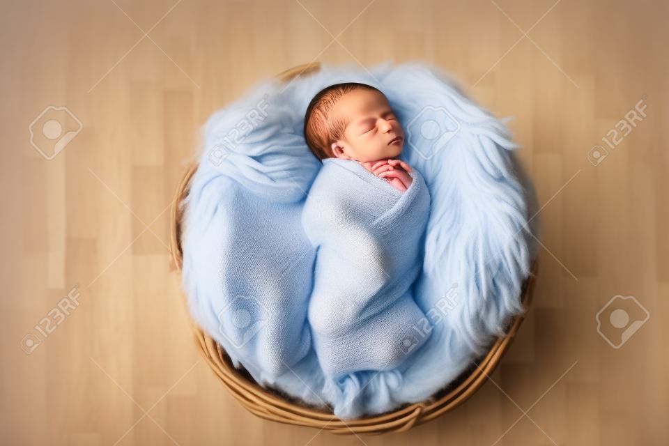 Little newborn baby sleeping in wooden basket on fluffy blanket, new youngest member of the family