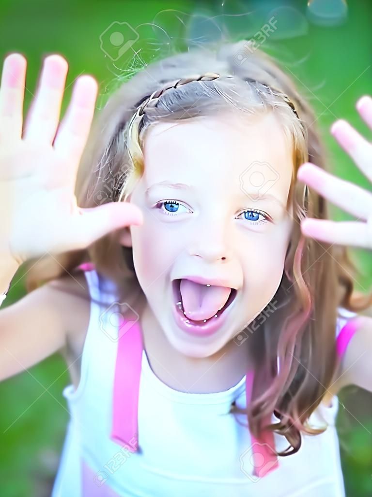 Porträt von einem niedlichen kleinen Mädchen, die Zunge zeigt nach dem Verzehr von Beeren