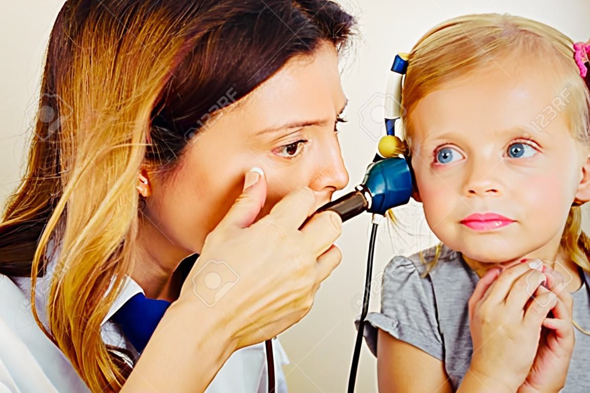 작은 girl`s 귀를 검사하는 소아과 의사.