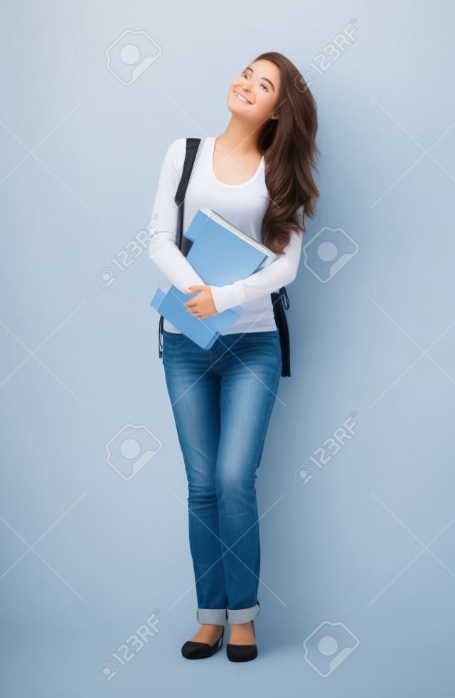 Młoda studentka szuka patrząc w górę na białym tle.