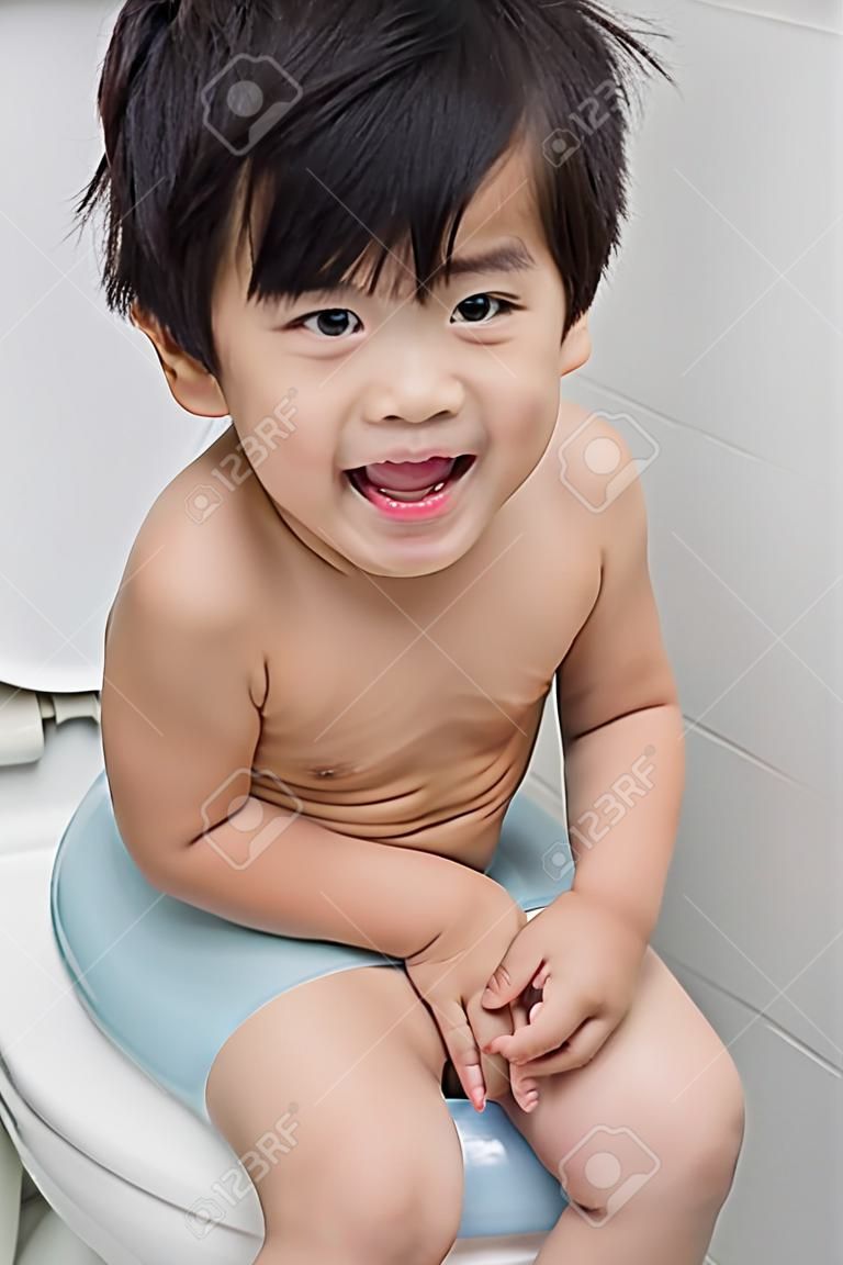 Cute Asian ребенок на туалетном современном стиле.