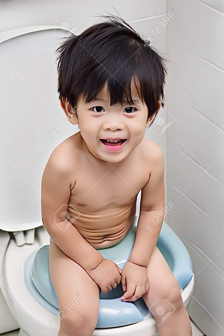 Cute asian child on the toilet modern style.
