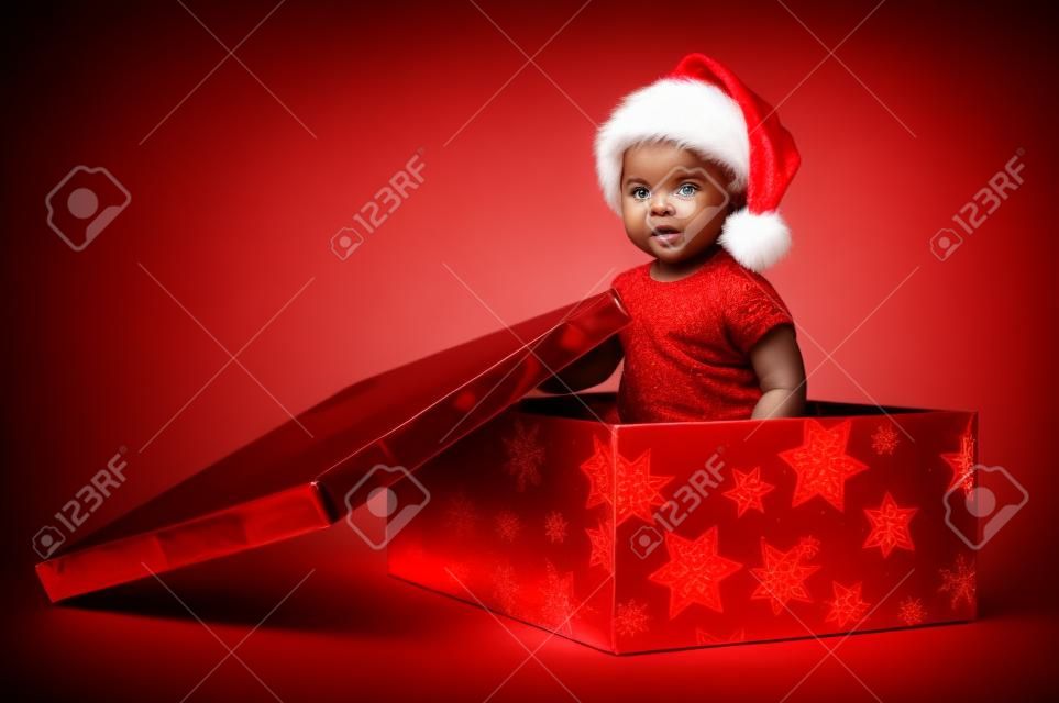 Hermoso bebé negro dentro de una caja roja de Navidad
