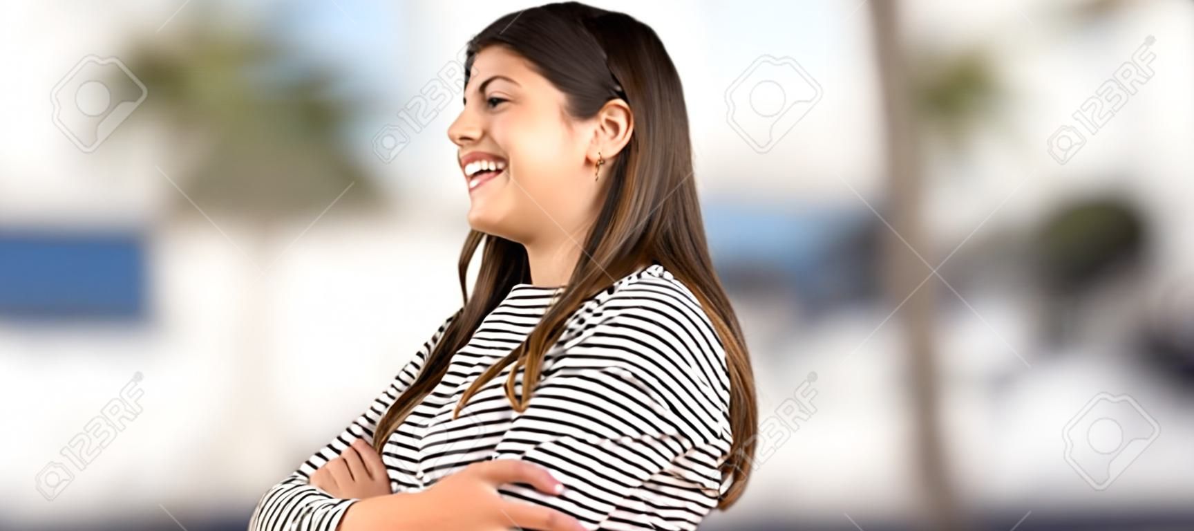 Teenager-Mädchen mit gestreiftem Hemd Glücklich und lächelnd im Freien