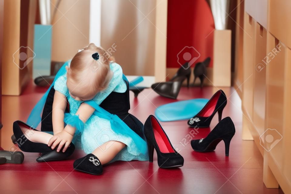 Little girl wearing big high-heeled mothers shoes