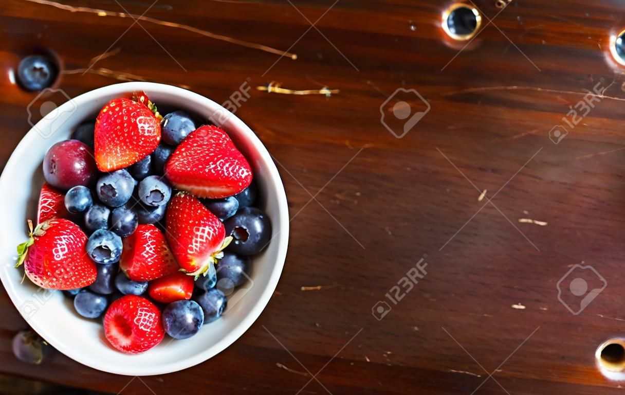먹을 준비가 된 흰색 그릇에 딸기와 블루베리