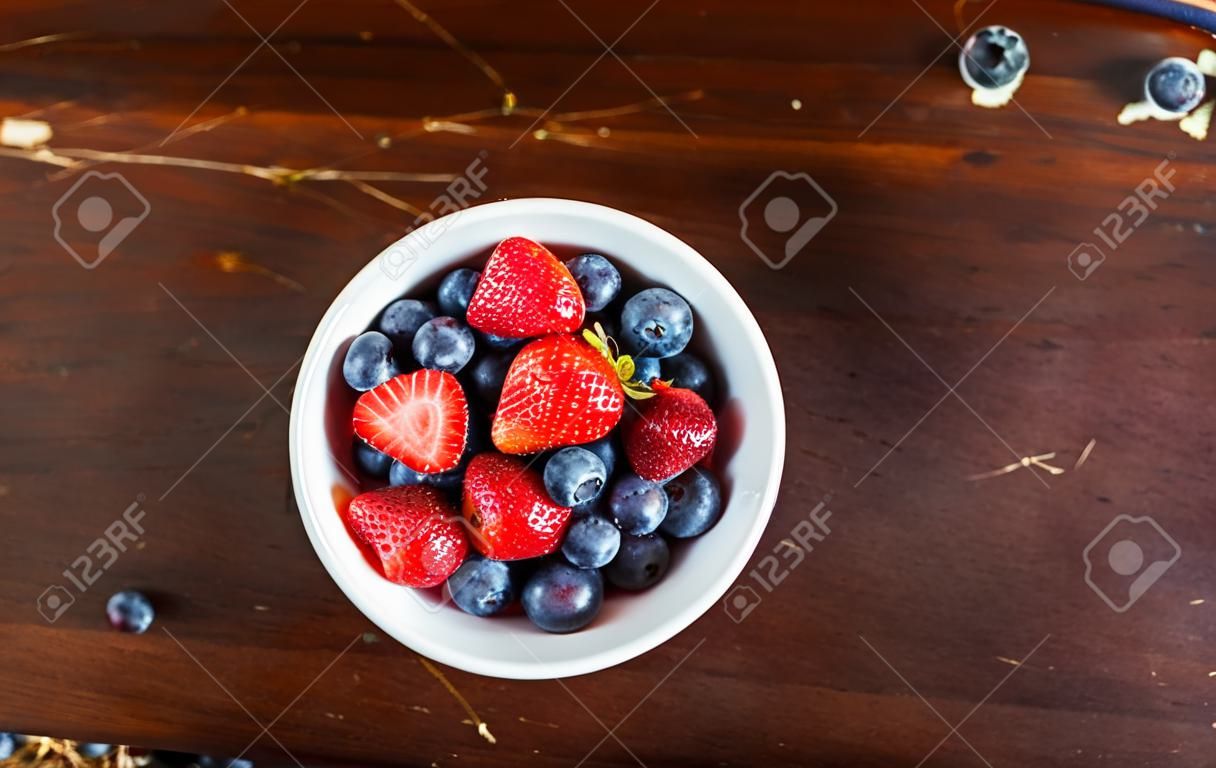 먹을 준비가 된 흰색 그릇에 딸기와 블루베리