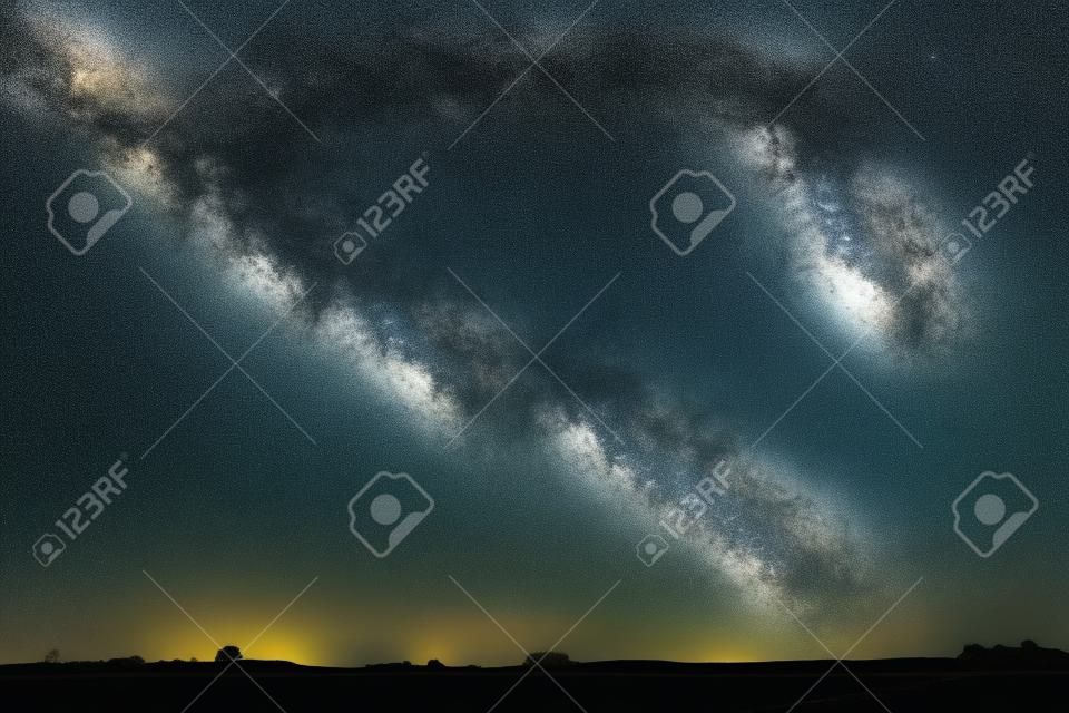 Night landscape image with colorful milky way and yellow light in the horizon