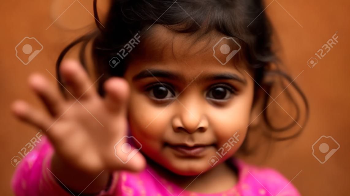 Ritratto di una bambina indiana carina che mostra il gesto di arresto con la mano