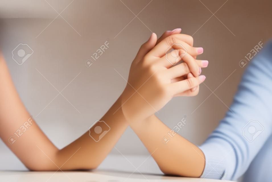 Beautiful female hands holding together with fingers crossed