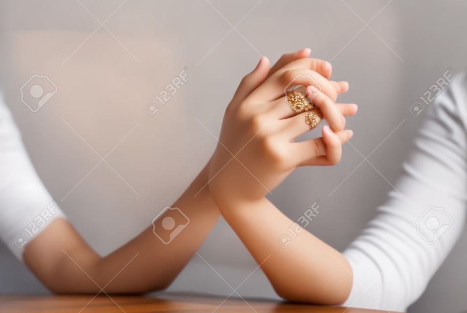 Beautiful female hands holding together with fingers crossed
