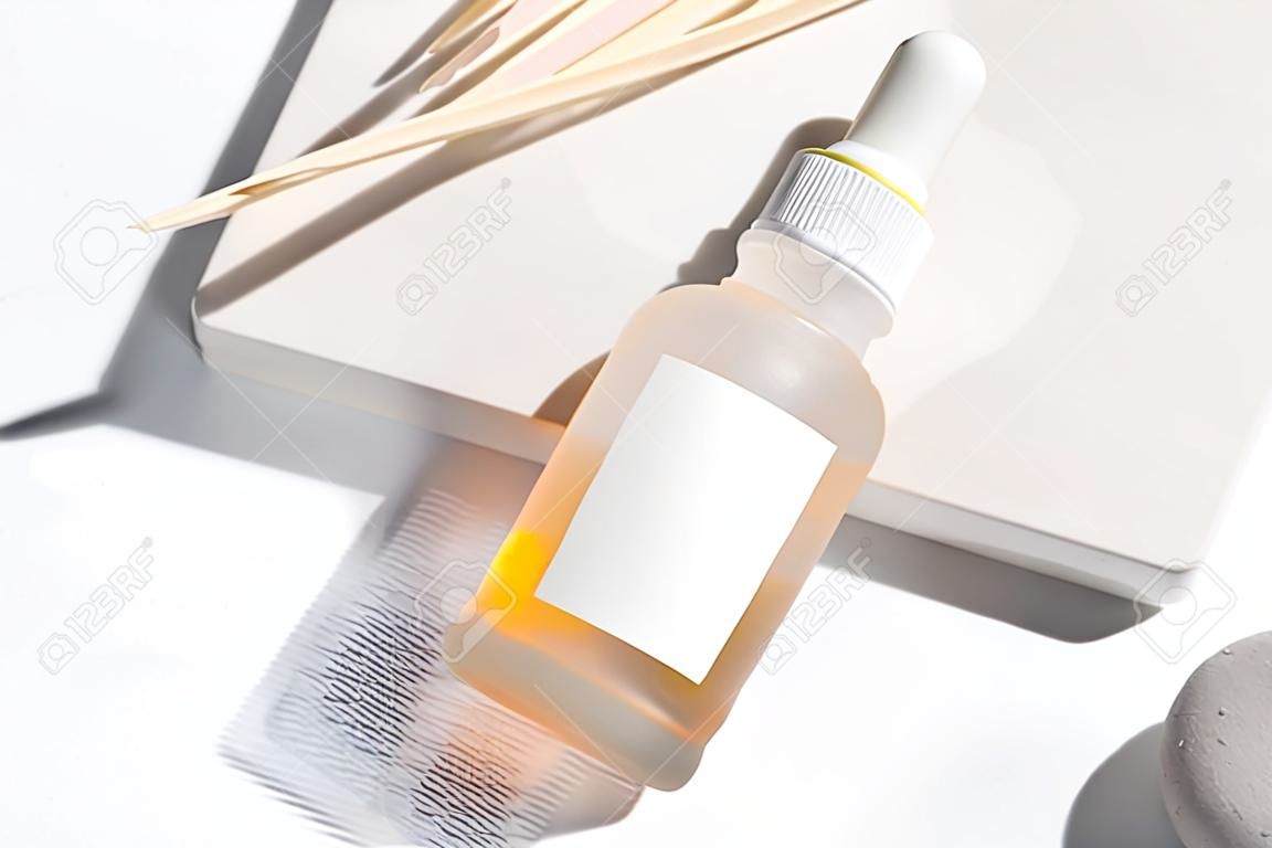 Nahaufnahme gelber Serumessenz in Glasflasche auf weißem Standhintergrund. Isoliertes Hautpflegeöl