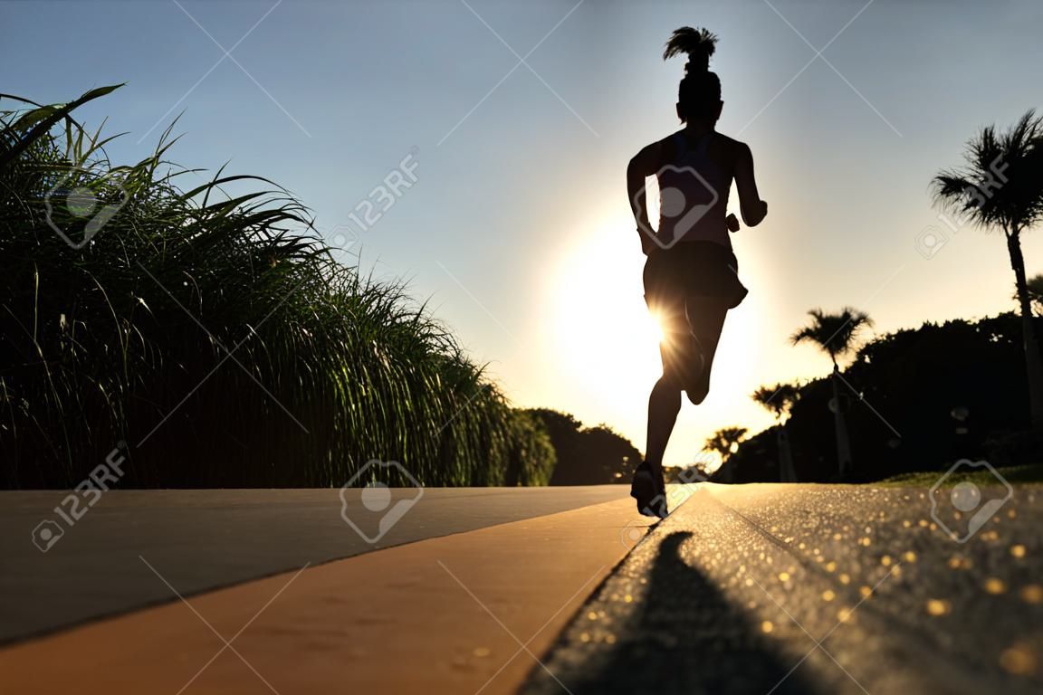 junge Frau Fitness auf Sonnenaufgang am Meer Trail Running