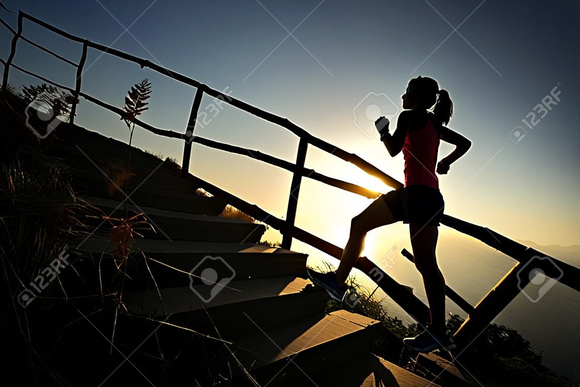 jovem fitness mulher trail runner running para cima em escadas de montanha