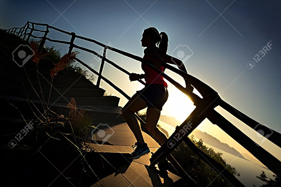 Fitness mujer joven corredor de pista procesamiento de escaleras de montaña