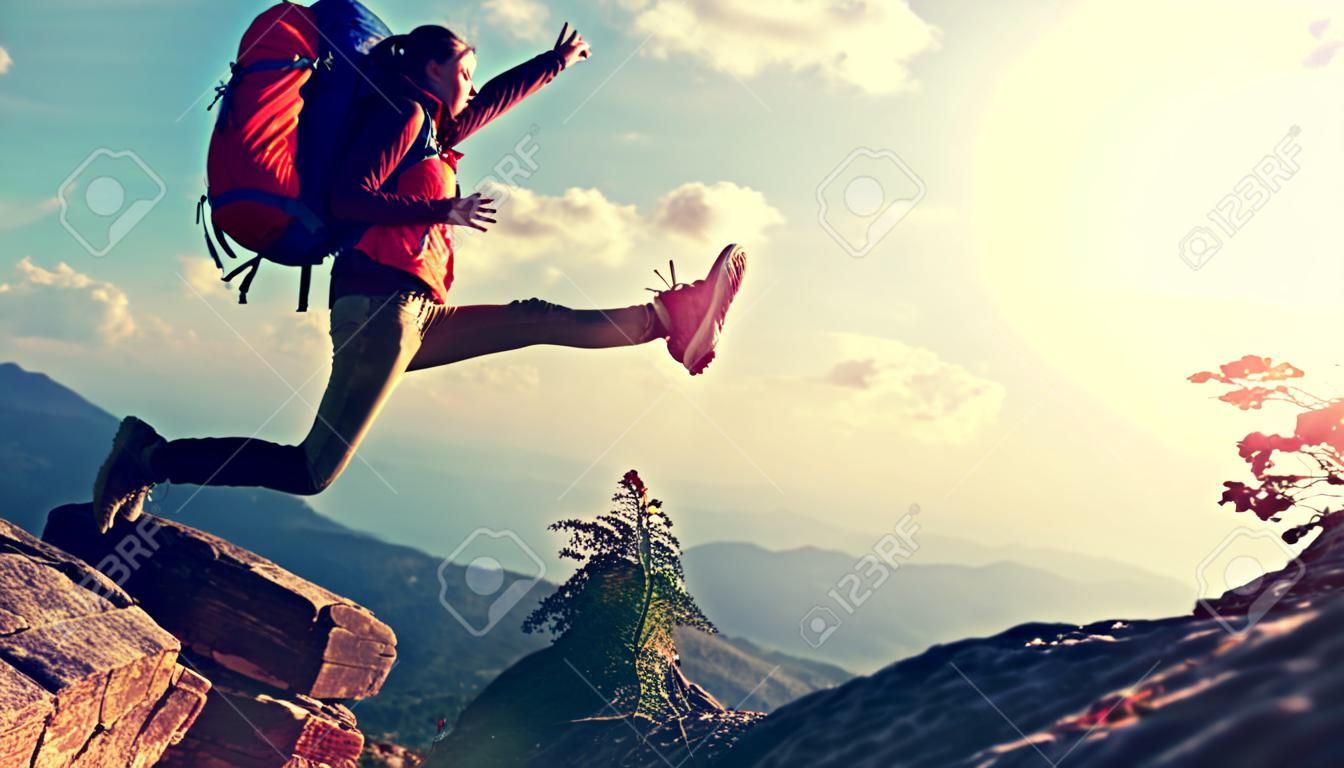 juichen succesvolle jonge vrouw wandelen springen op de berg piek