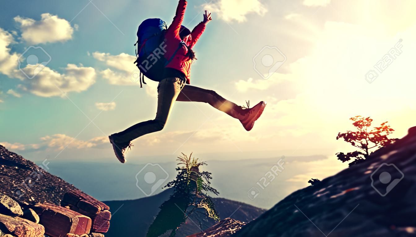 juichen succesvolle jonge vrouw wandelen springen op de berg piek