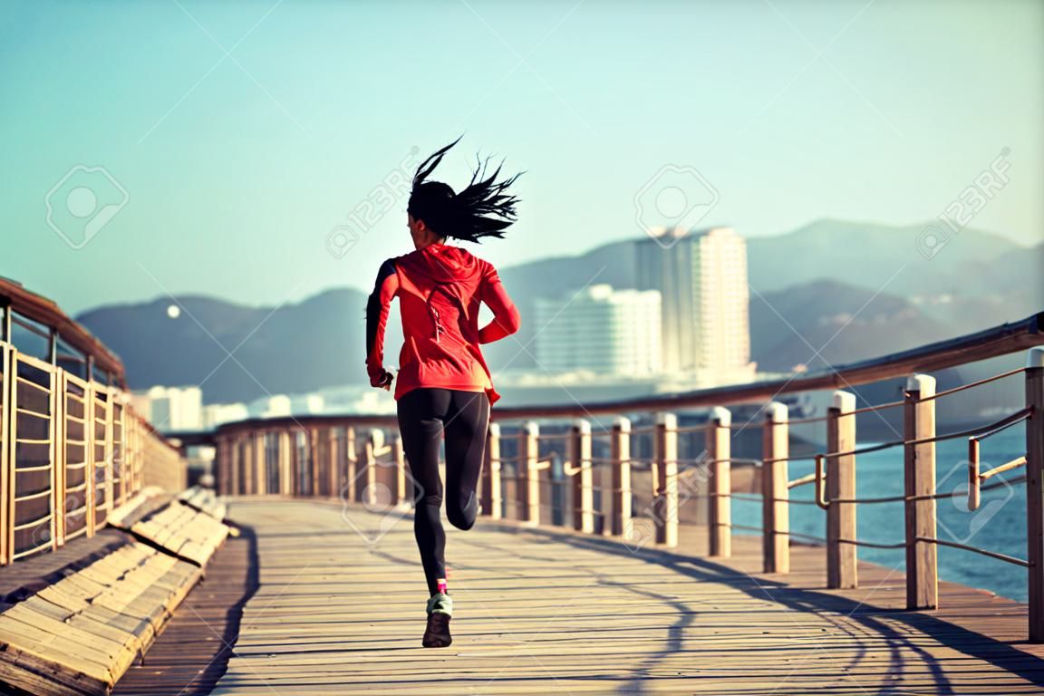 Sportliche Fitness weibliche Läufer läuft auf Strandpromenade
