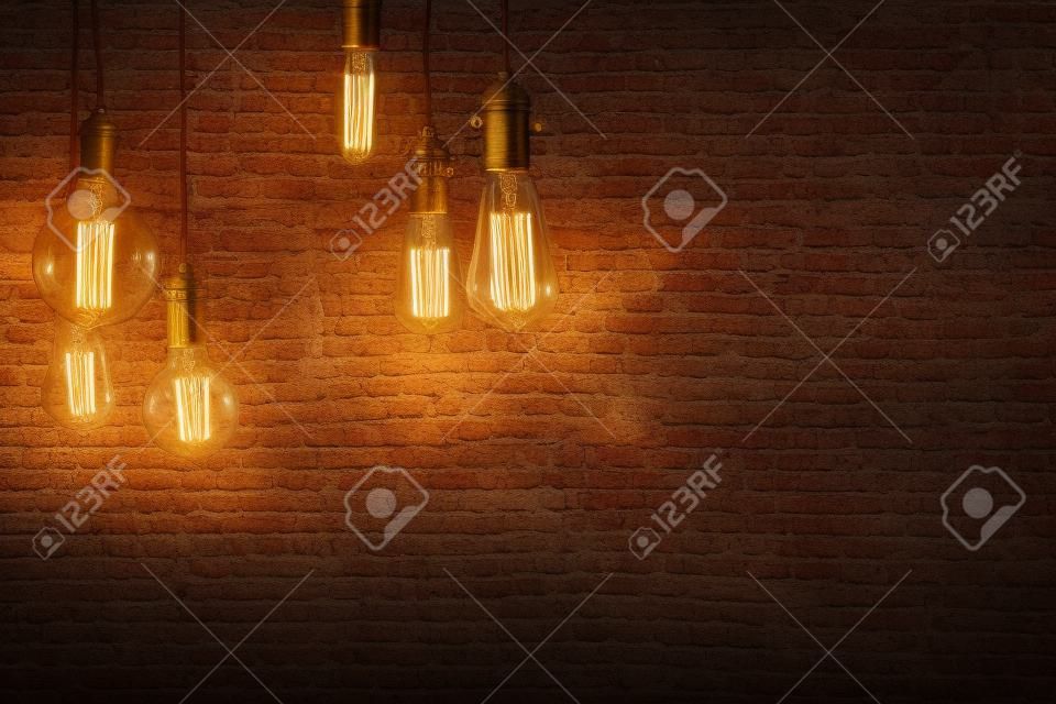 装饰仿古爱迪生风格的灯泡反对砖墙背景