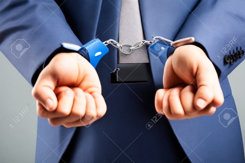 A picture of a businessman in handcuffs 