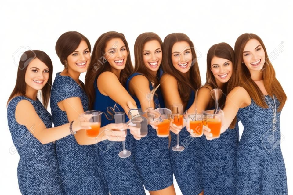 A portrait of seven girlfriends in party moods smiling and drinking over white background