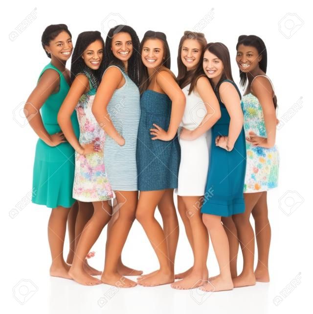 Un portrait de sept copines, debout dans une rangée et souriant sur fond blanc