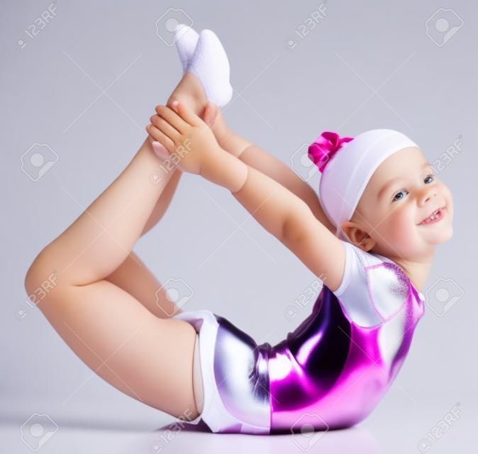 Jeune fille mignonne faire de la gymnastique sur fond blanc