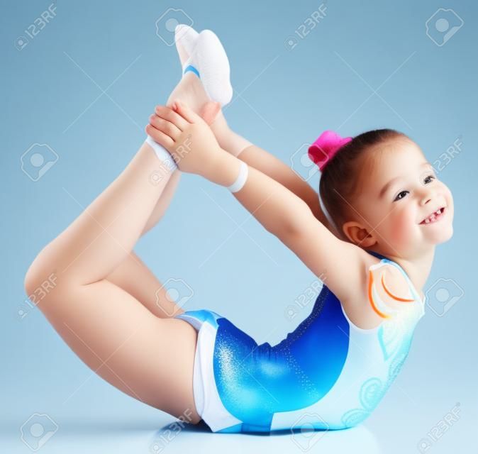 Молодая симпатичная девушка делает гимнастику на белом фоне