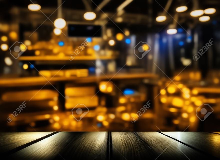 Oberseite des Holztischs mit Lichtreflexion mit gelber abstrakter Unschärfebar oder Verein im dunklen Nachthintergrund