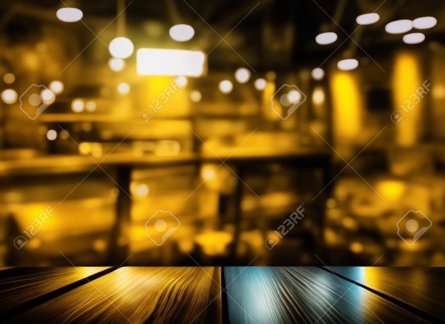 Oberseite des Holztischs mit Lichtreflexion mit gelber abstrakter Unschärfebar oder Verein im dunklen Nachthintergrund