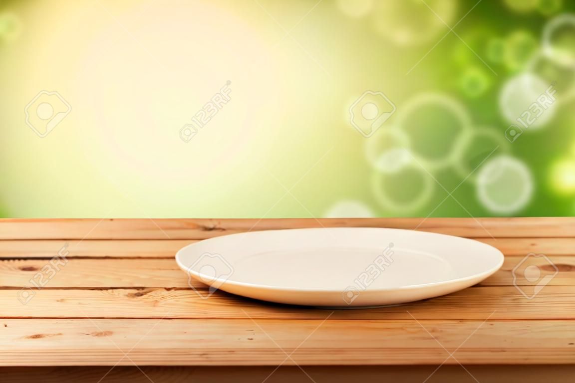 Leere Teller auf Holztisch über Bokeh Hintergrund