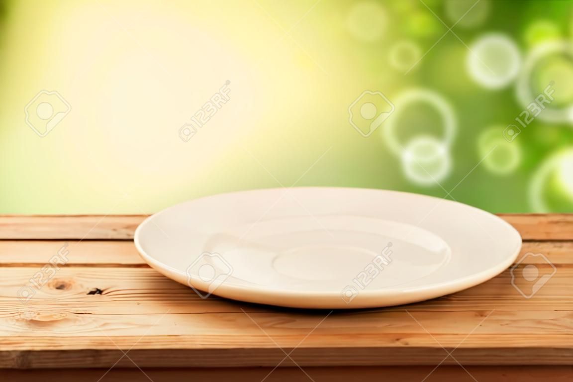 Leere Teller auf Holztisch über Bokeh Hintergrund