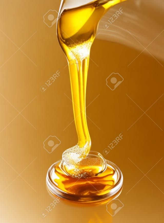 Gießen Honig isoliert auf weißem Hintergrund